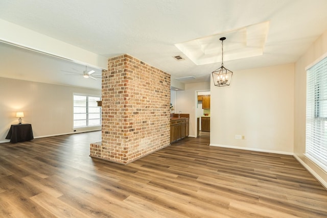 2910 Castle Ct, Pearland, TX 77581 - unfurnished living room featuring wood finished floors, a chandelier, a raised ceiling, and ceiling fan