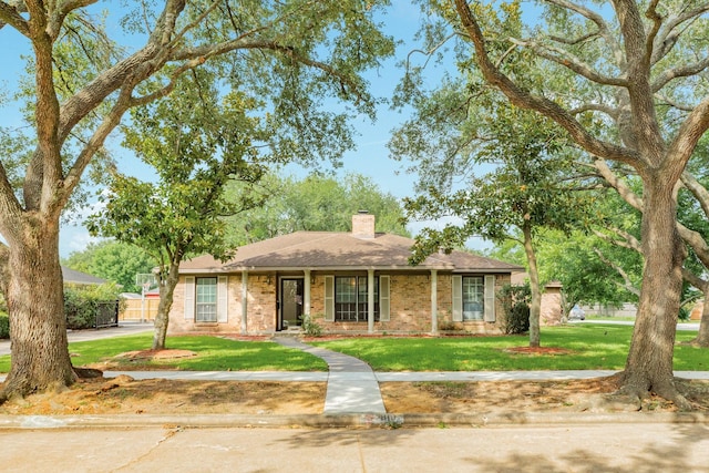 2910 Castle Ct, Pearland, TX 77581 - ranch-style house with a front yard, a chimney, brick siding, and roof with shingles