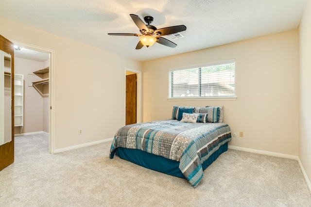 2910 Castle Ct, Pearland, TX 77581 - carpeted bedroom featuring a walk in closet and a ceiling fan