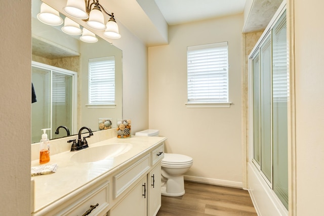 2910 Castle Ct, Pearland, TX 77581 - bathroom with vanity, wood finished floors, and bath / shower combo with glass door