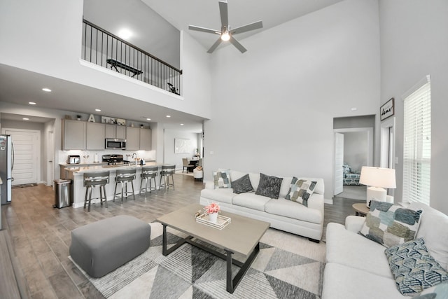 3334 Fogmist Dr, Rosenberg, TX 77471 - living room with a towering ceiling, light wood-style flooring, and a ceiling fan