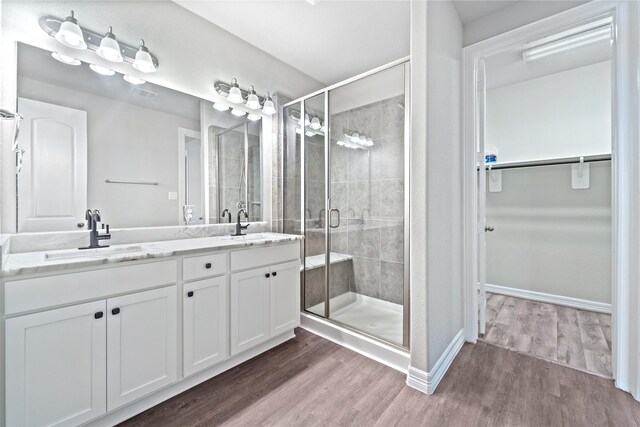 1510 Upland Glen Way, Houston, TX 77043 - full bathroom featuring double vanity, a walk in closet, a stall shower, and wood finished floors