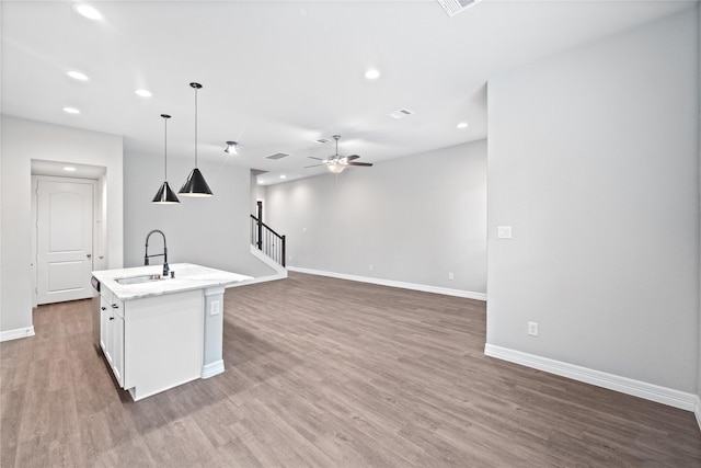 1510 Upland Glen Way, Houston, TX 77043 - kitchen with light wood-style flooring, a ceiling fan, a center island with sink, white cabinetry, and open floor plan