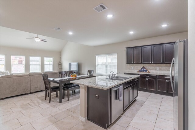 9418 Mcdowell Dr, Richmond, TX 77469 - kitchen with appliances with stainless steel finishes, open floor plan, a kitchen island with sink, tasteful backsplash, and light tile patterned floors
