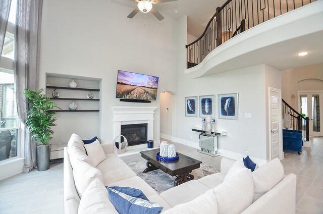 8703 Silver Crest Ln, Missouri City, TX 77459 - living area featuring a high ceiling, stairs, a ceiling fan, a glass covered fireplace, and recessed lighting