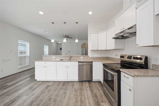 7430 N Star St, Houston, TX 77088 - kitchen with stainless steel appliances, under cabinet range hood, a peninsula, ceiling fan, and white cabinets