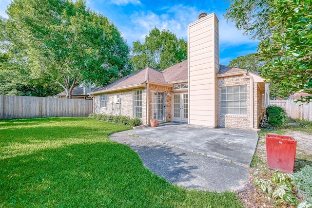 5007 Maple Brook Ln, Kingwood, TX 77345 - view of front of home with a patio, a fenced backyard, a chimney, brick siding, and french doors