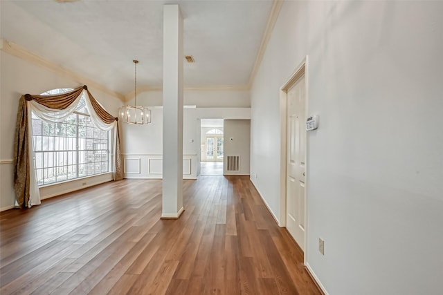 5007 Maple Brook Ln, Kingwood, TX 77345 - entrance foyer featuring crown molding, a chandelier, wood finished floors, a decorative wall, and a wainscoted wall