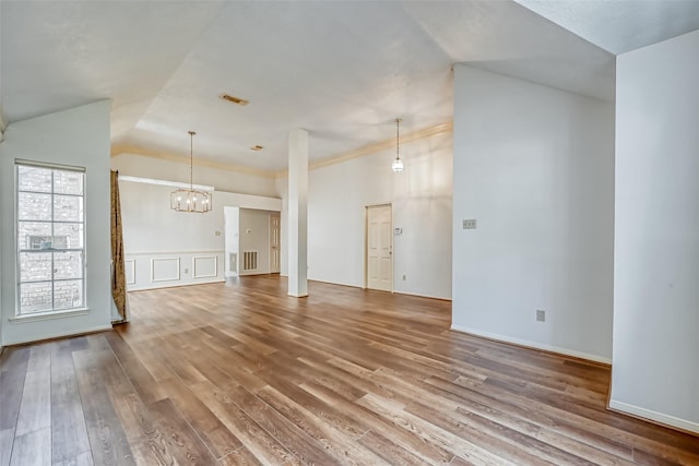 5007 Maple Brook Ln, Kingwood, TX 77345 - unfurnished living room featuring a chandelier, wood finished floors, and lofted ceiling