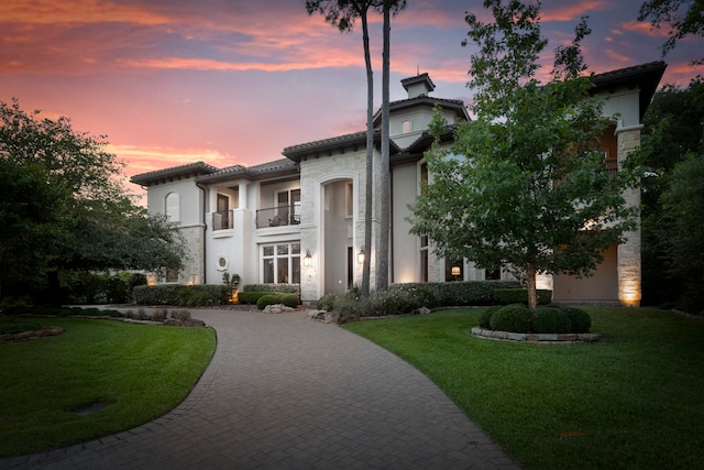 2 N Badger Lodge Cir, The Woodlands, TX 77389 - mediterranean / spanish-style house featuring a balcony, curved driveway, a lawn, stone siding, and stucco siding