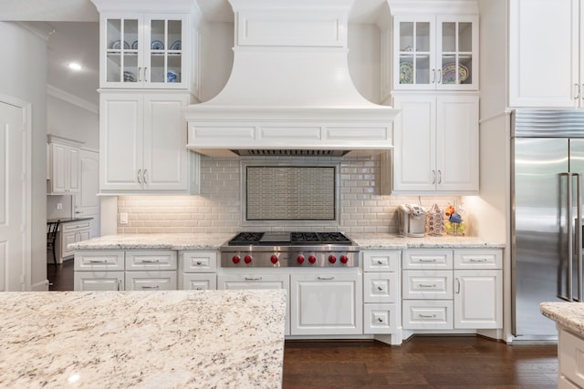 2 N Badger Lodge Cir, The Woodlands, TX 77389 - kitchen with stainless steel appliances, custom range hood, ornamental molding, dark wood-type flooring, and white cabinetry