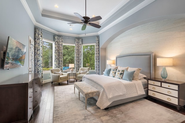 2 N Badger Lodge Cir, The Woodlands, TX 77389 - bedroom featuring wood-type flooring, arched walkways, a tray ceiling, a ceiling fan, and ornamental molding