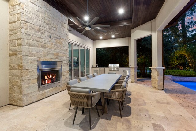 2 N Badger Lodge Cir, The Woodlands, TX 77389 - view of patio featuring an outdoor kitchen, an outdoor stone fireplace, a ceiling fan, outdoor dining area, and an outdoor pool