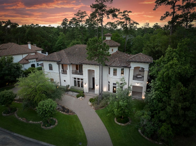 2 N Badger Lodge Cir, The Woodlands, TX 77389 - mediterranean / spanish-style home with a balcony, stone siding, and a front yard