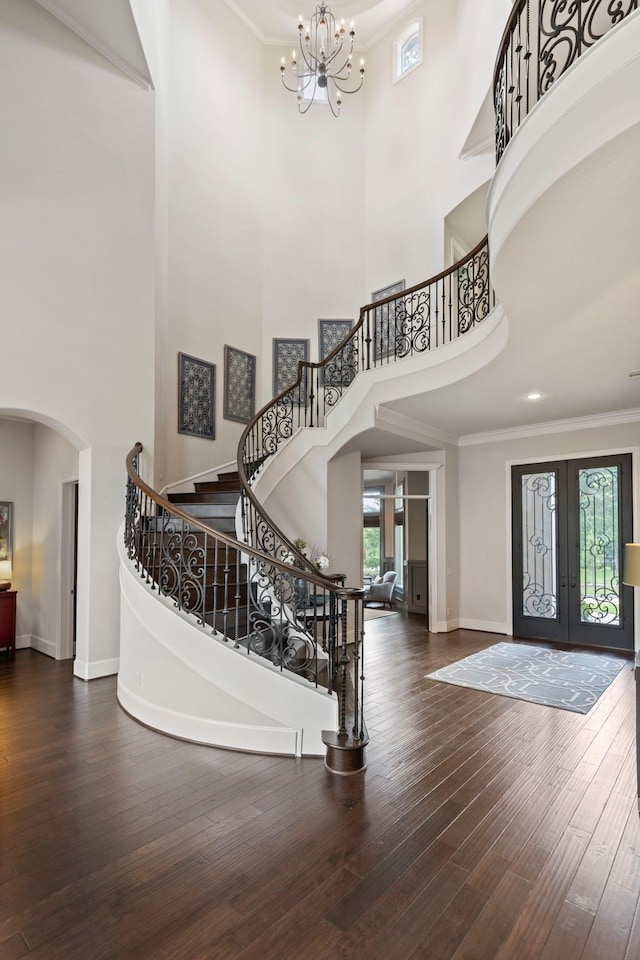 2 N Badger Lodge Cir, The Woodlands, TX 77389 - entrance foyer with a towering ceiling, arched walkways, stairway, a chandelier, and hardwood / wood-style flooring