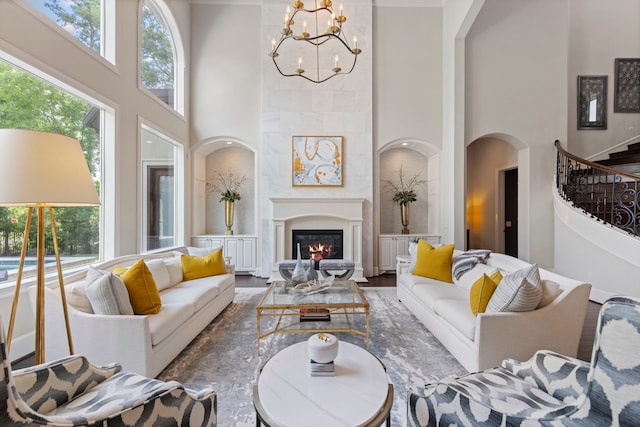 2 N Badger Lodge Cir, The Woodlands, TX 77389 - living room with a towering ceiling, plenty of natural light, a chandelier, a glass covered fireplace, and arched walkways