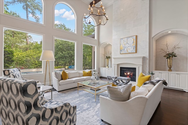 2 N Badger Lodge Cir, The Woodlands, TX 77389 - living area with a towering ceiling, a chandelier, a glass covered fireplace, dark wood-style flooring, and ornamental molding