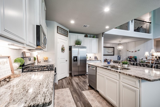 18202 Octavio Frias Trl, Houston, TX 77044 - kitchen with stainless steel appliances, dark wood-type flooring, white cabinetry, a center island with sink, and recessed lighting