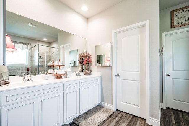 18202 Octavio Frias Trl, Houston, TX 77044 - bathroom featuring a stall shower, double vanity, wood finished floors, and recessed lighting