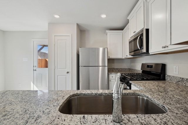 425 Tejas Trl, Waller, TX 77484 - kitchen with appliances with stainless steel finishes, light stone counters, white cabinetry, and recessed lighting