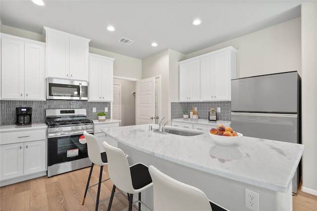 426 Emerald Thicket Ln, Huffman, TX 77336 - kitchen featuring appliances with stainless steel finishes, white cabinetry, decorative backsplash, and recessed lighting