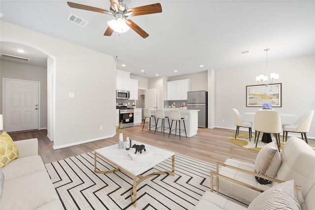426 Emerald Thicket Ln, Huffman, TX 77336 - living area featuring ceiling fan, arched walkways, light wood-type flooring, a chandelier, and recessed lighting