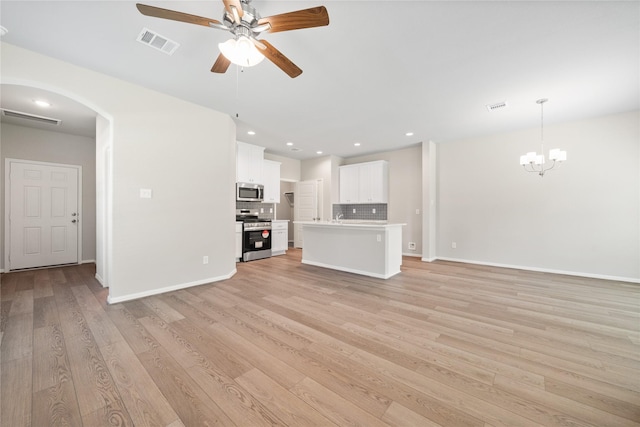 426 Emerald Thicket Ln, Huffman, TX 77336 - unfurnished living room with arched walkways, ceiling fan, light wood-type flooring, a chandelier, and recessed lighting