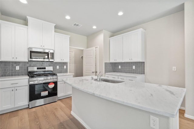 426 Emerald Thicket Ln, Huffman, TX 77336 - kitchen with stainless steel appliances, white cabinets, decorative backsplash, and recessed lighting