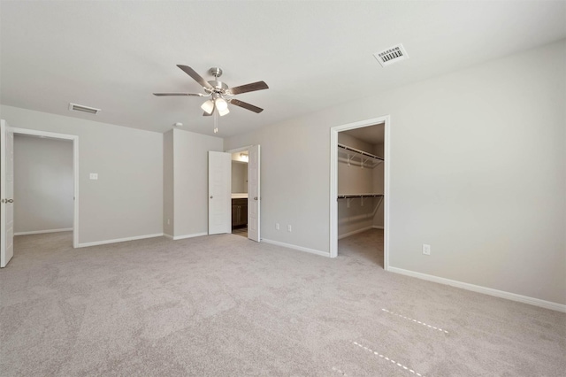 426 Emerald Thicket Ln, Huffman, TX 77336 - unfurnished bedroom featuring light carpet, a walk in closet, a ceiling fan, and a closet
