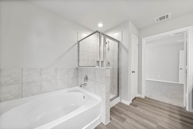 426 Emerald Thicket Ln, Huffman, TX 77336 - full bath featuring a bath, a shower stall, and wood finished floors