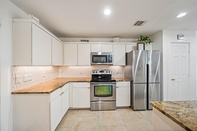 151 Anise Tree Pl, The Woodlands, TX 77382 - kitchen featuring appliances with stainless steel finishes, tasteful backsplash, white cabinetry, light stone counters, and recessed lighting
