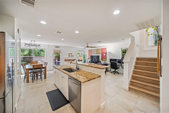 151 Anise Tree Pl, The Woodlands, TX 77382 - kitchen with stainless steel appliances, an island with sink, recessed lighting, light stone counters, and open floor plan