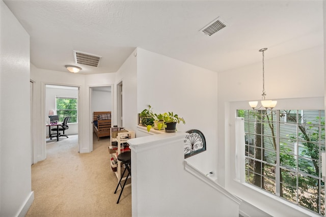 151 Anise Tree Pl, The Woodlands, TX 77382 - hallway featuring an upstairs landing, a chandelier, and light carpet