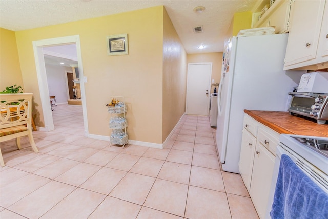 16841 Aprilmont Dr, Sugar Land, TX 77498 - kitchen with tile countertops, light tile patterned floors, electric stove, white cabinets, and a textured ceiling