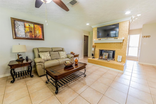 16841 Aprilmont Dr, Sugar Land, TX 77498 - living room featuring a textured ceiling, a ceiling fan, light tile patterned flooring, a brick fireplace, and recessed lighting