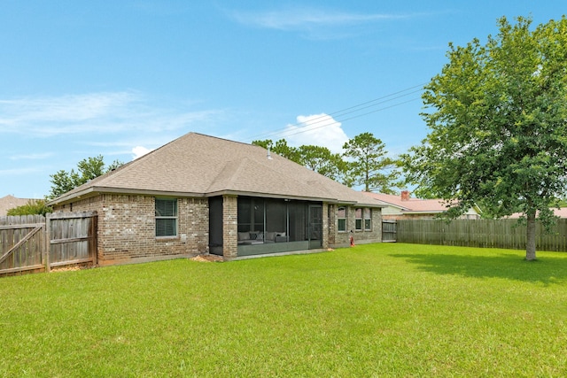 203 Poppy St, Lake Jackson, TX 77566 - rear view of house with a fenced backyard, brick siding, a sunroom, and roof with shingles