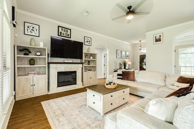 203 Poppy St, Lake Jackson, TX 77566 - living area with arched walkways, crown molding, a ceiling fan, wood finished floors, and a glass covered fireplace