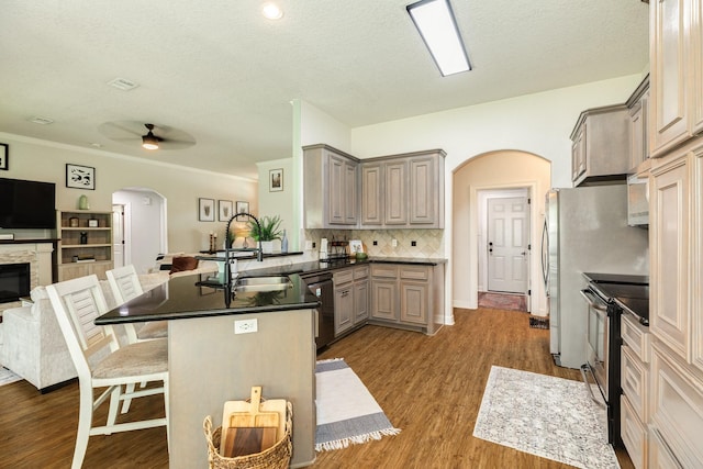 203 Poppy St, Lake Jackson, TX 77566 - kitchen with arched walkways, stainless steel appliances, gray cabinetry, open floor plan, and a textured ceiling