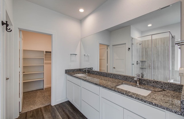 309 Pleasant Hill Way, Conroe, TX 77304 - full bathroom with a stall shower, wood finished floors, double vanity, a walk in closet, and recessed lighting