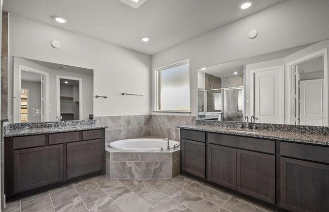 7827 Albury Mnr, Richmond, TX 77407 - full bathroom featuring a stall shower, two vanities, a garden tub, recessed lighting, and a walk in closet