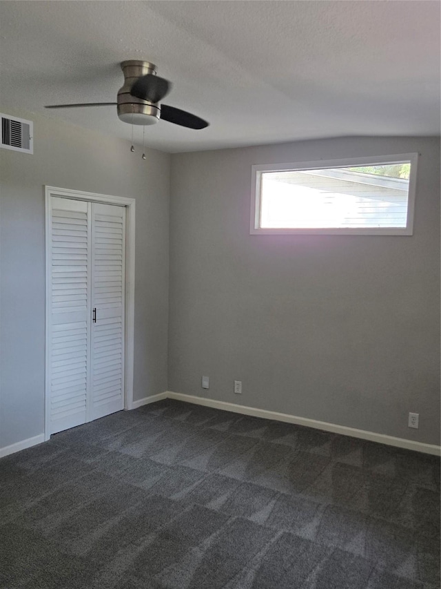 204 Jasmine St, Lake Jackson, TX 77566 - unfurnished bedroom featuring dark carpet, a ceiling fan, and a closet