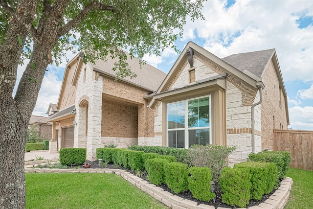 25603 Kearsley Dr, Katy, TX 77494 - view of home's exterior featuring stone siding, brick siding, a shingled roof, and driveway