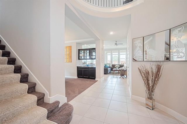 25603 Kearsley Dr, Katy, TX 77494 - foyer entrance with stairway, light tile patterned flooring, a ceiling fan, light colored carpet, and a high ceiling