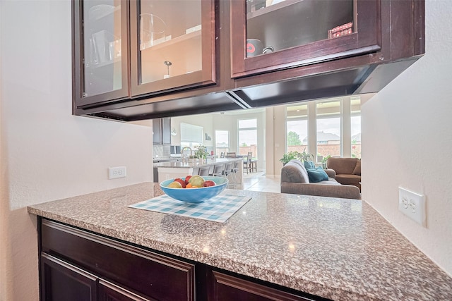 25603 Kearsley Dr, Katy, TX 77494 - kitchen with glass insert cabinets, dark brown cabinetry, and open floor plan
