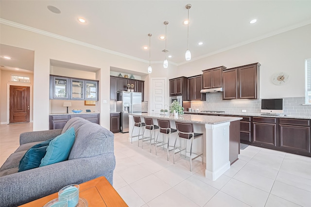 25603 Kearsley Dr, Katy, TX 77494 - kitchen featuring stainless steel fridge, open floor plan, a kitchen breakfast bar, dark brown cabinetry, and backsplash