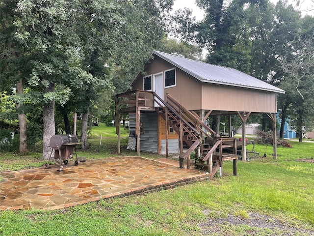 521 Northwood Dr, Point Blank, TX 77364 - back of house with a metal roof, a patio, stairs, a yard, and a wooden deck