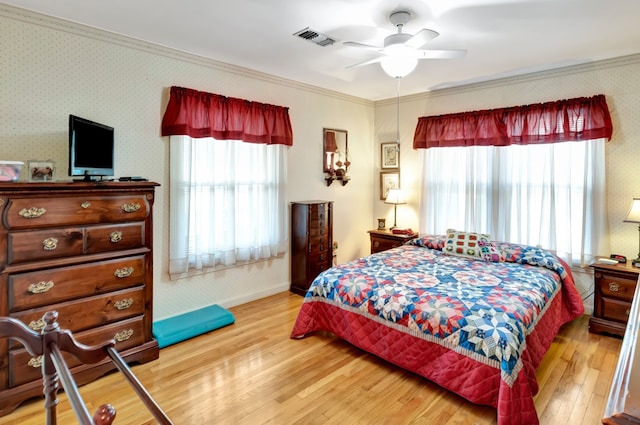 820 Meadow Ln, Wharton, TX 77488 - bedroom with multiple windows, crown molding, light wood-style floors, wallpapered walls, and a ceiling fan