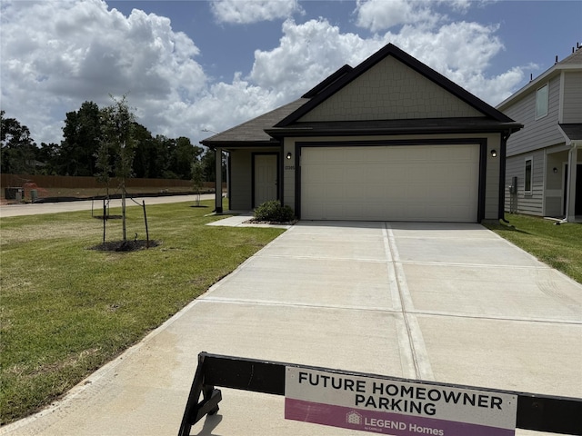13305 Burbot Dr, Conroe, TX 77384 - view of front of home with a front yard, concrete driveway, and an attached garage