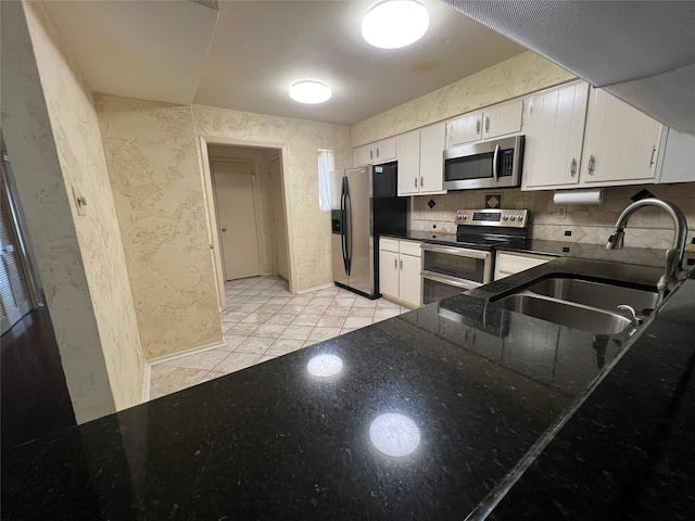 14515 Wunderlich Dr Unit 708, Houston, TX 77069 - kitchen featuring appliances with stainless steel finishes, white cabinetry, light tile patterned floors, and dark stone counters