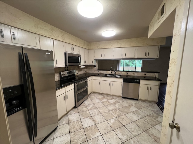 14515 Wunderlich Dr Unit 708, Houston, TX 77069 - kitchen featuring appliances with stainless steel finishes, dark countertops, light tile patterned floors, white cabinetry, and decorative backsplash